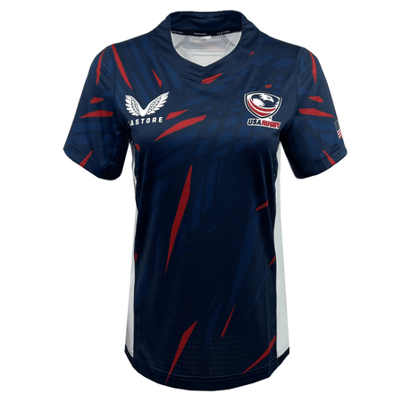 The Women's USA Rugby 23/24 Pro Home Jersey by Castore features a navy blue design with red and blue diagonal streaks, short sleeves, and Castore and USA Rugby logos on the chest.