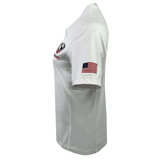 The Women's USA Rugby Training Jersey by Castore features a small embroidered U.S. flag on the sleeve and a partially visible logo on the front. Its moisture-wicking fabric ensures comfort, while the athletic fit enhances performance, adding a subtle touch of style.