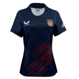 The Women's USA Rugby 2024 Olympic 7's Jersey by Castore is navy blue with a "USA" crest, red-striped design, and an American flag on the sleeve. Made from performance fabric, it combines style with athletic excellence.