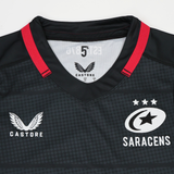 Close-up of the Women's Saracens Home Replica Jersey 24/25 by Castore, a black jersey with red trim, showcasing the Castore logo and Saracens club emblem on the chest.