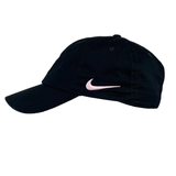 A black and pink adjustable hat featuring a pink Nike swoosh logo on the front-left panel, inspired by the classic Stade Toulousain Heritage 86 Cap by Nike.