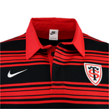 The Stade Toulousain 25/26 Heritage Long Sleeve Rugby Jersey by Nike features black and red stripes, a Nike logo, and a shield-shaped "ST" badge on the chest.