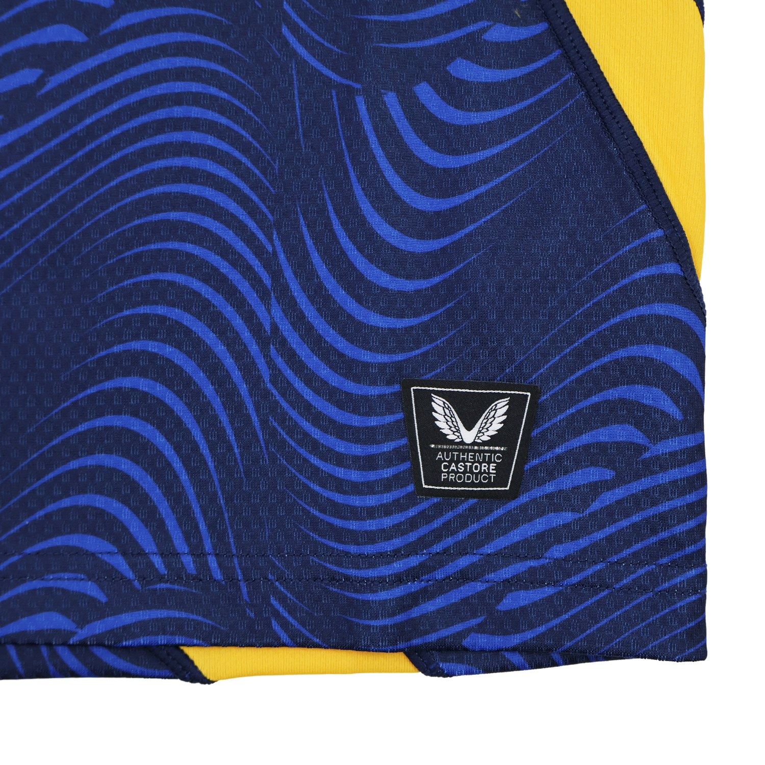 Close-up of the Leinster 25/26 Third Pro Shirt by Castore, featuring dark blue and yellow colors, wavy blue patterns, and an "Authentic Castore Product" label with a winged logo.