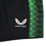 Close-up of the Harlequins 22/23 Home Shorts by Castore, featuring black fabric, a green zigzag side pattern, and the white Castore logo with stylized wings.