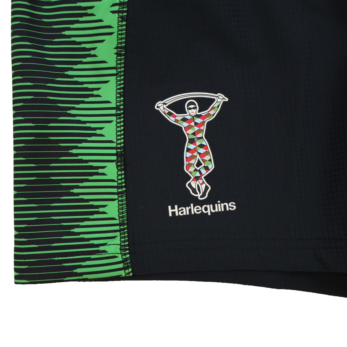 Close-up of Castore Harlequins 22/23 Home Shorts, featuring black fabric with green geometric patterns and the iconic multicolored harlequin rugby logo.