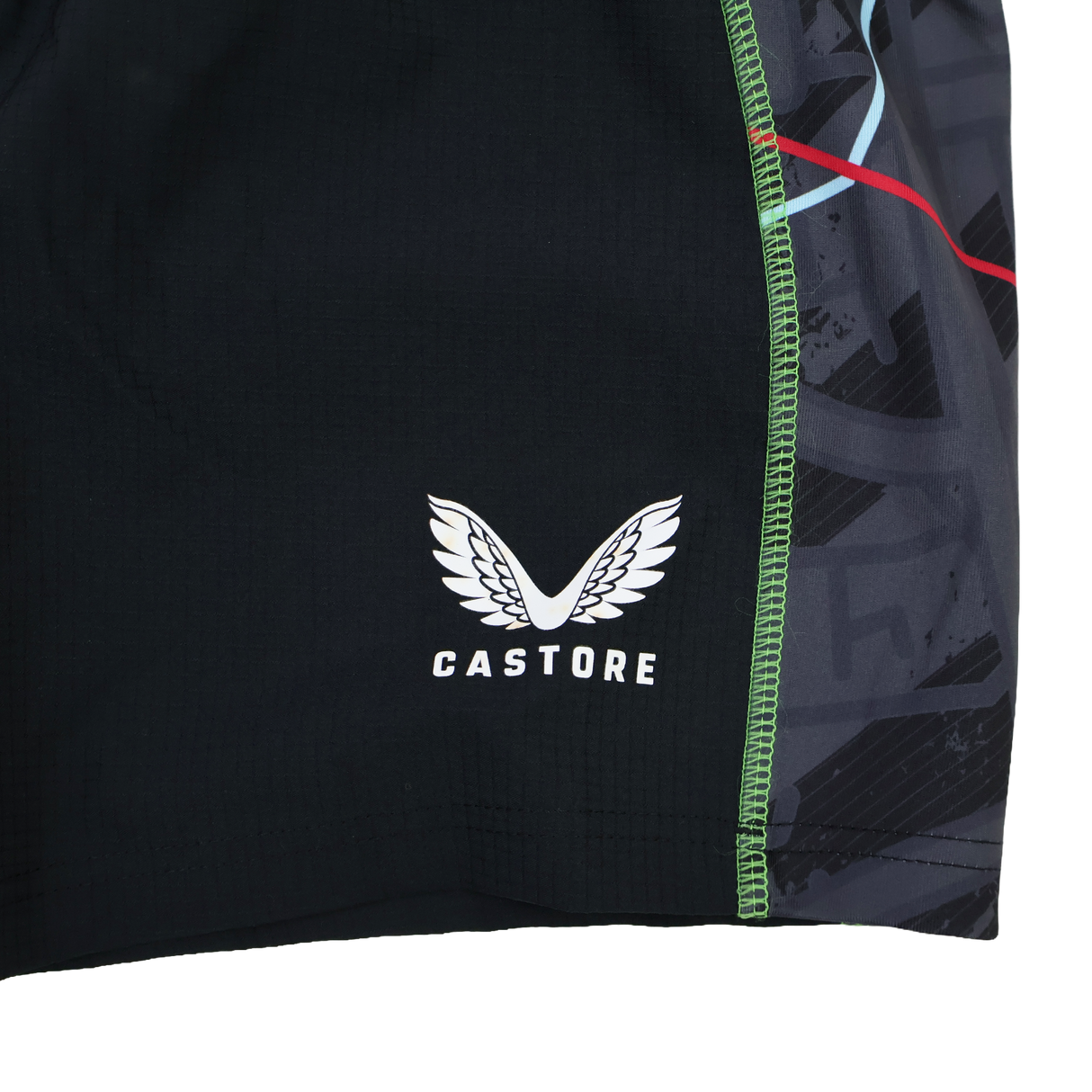 Close-up of the Harlequins 22/23 3rd Pro Short by Castore, showcasing black fabric with the white wings logo and green seam stitching, inspired by classic rugby style.