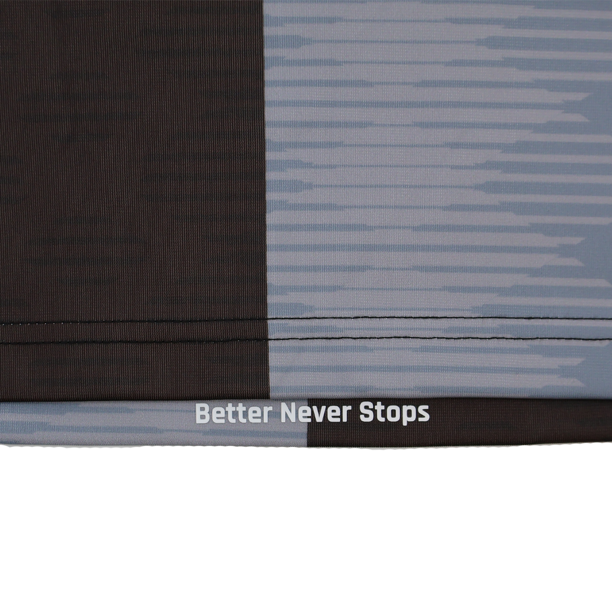 Close-up of fabric from the Harlequins Replica Home Jersey 22/23 by Castore, showing a dark and light geometric design with "Better Never Stops" printed near a seam.