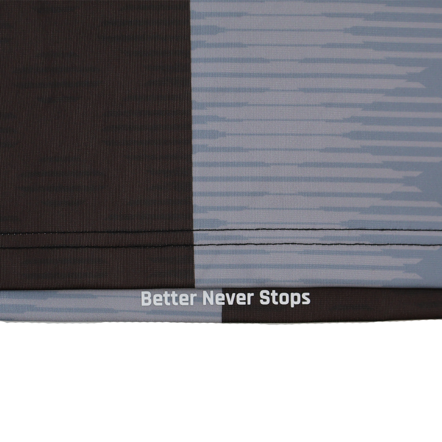 Close-up of fabric from the Harlequins Replica Home Jersey 22/23 by Castore, showing a dark and light geometric design with "Better Never Stops" printed near a seam.