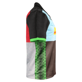 The Castore Harlequins Replica Home Jersey 22/23 is a short-sleeve polo featuring multicolored geometric panels in black, red, green, blue, gray, and brown, shown from the left side.