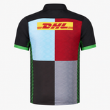 The Harlequins Replica Home Jersey 22/23 by Castore features four colored back panels (light blue, maroon, black, gray), black sleeves with green trim, a yellow DHL logo on the upper back, and authentic Castore detailing.