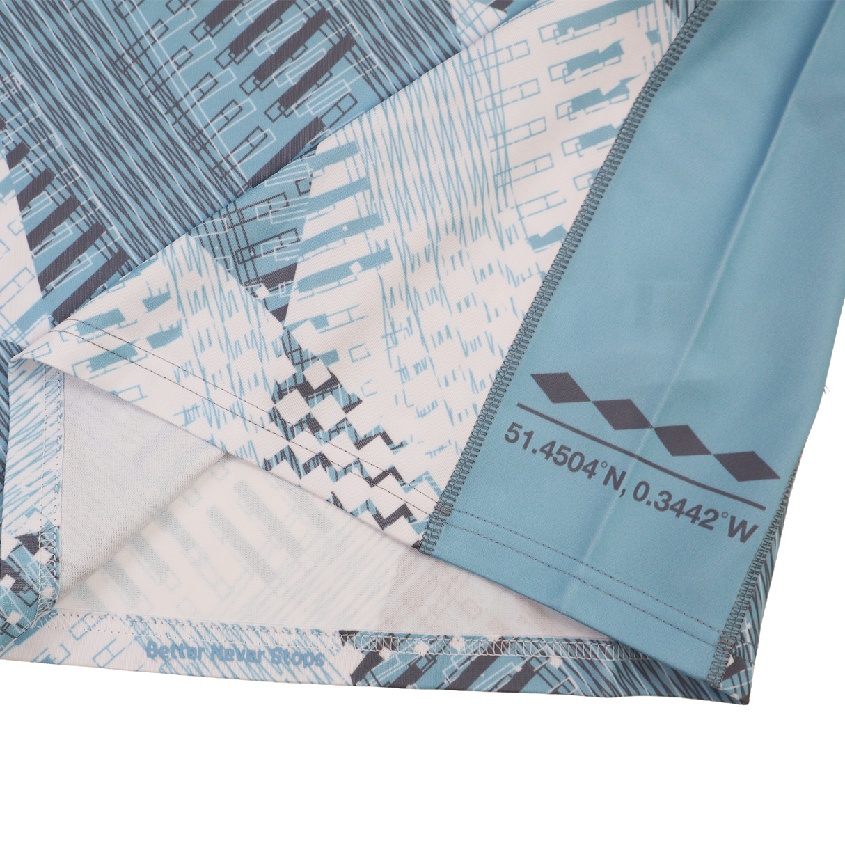 Close-up of blue and white patterned fabric from the Harlequins Replica Away Jersey 22/23 by Castore, showing printed coordinates "51.4504°N, 0.3442°W" and geometric shapes along the seam.