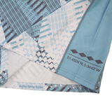 Close-up of blue and white patterned fabric from the Harlequins Replica Away Jersey 22/23 by Castore, showing printed coordinates "51.4504°N, 0.3442°W" and geometric shapes along the seam.