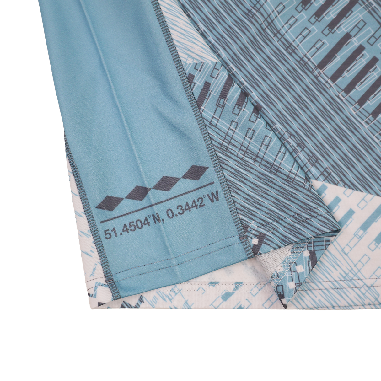 A close-up of the Harlequins Replica Away Jersey 22/23 by Castore, showing its blue geometric pattern, white accents, and printed coordinates: 51.4504°N, 0.3442°W.