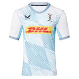 The Harlequins Replica Away Jersey 22/23 by Castore features a white and light blue geometric pattern, DHL sponsor logo, Castore branding, and club crest on the chest—a perfect rugby jersey for fans.