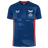 The Scarlets Training Tee 22/23 by Castore features blue short sleeves, an athletic fit, geometric patterns, white sponsor and team logos on the chest, and bold red side panels.