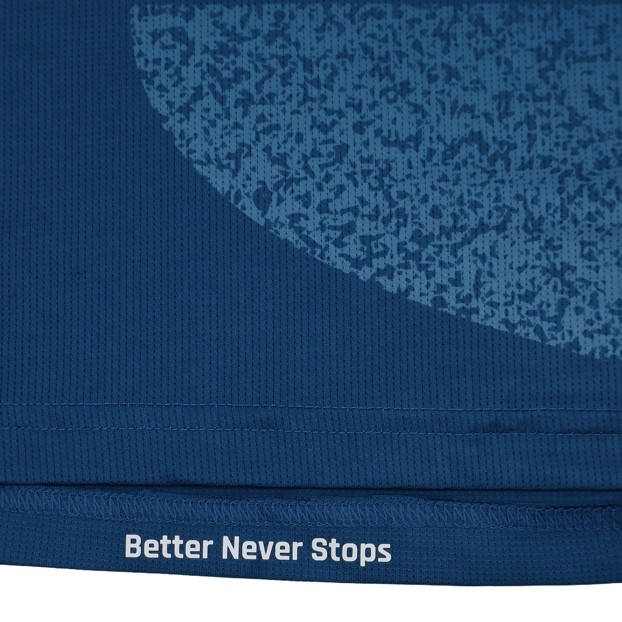 Close-up of the blue Scarlets Training Tee 22/23 by Castore, featuring a textured pattern and "Better Never Stops" printed in white along the bottom edge.