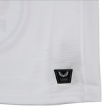 Close-up of the lower part of the Ulster 25/26 Pro Home Jersey by Castore, showing a black "Authentic Fabrique" patch with a winged logo near the hem, designed in Castore's signature performance style.