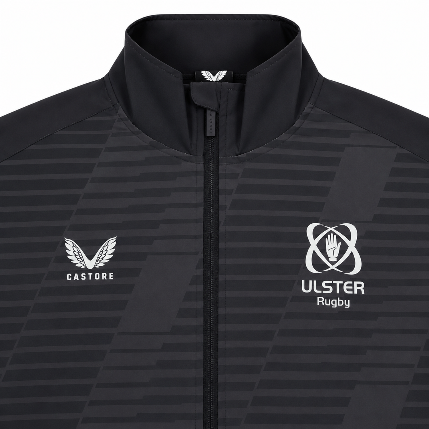 The Ulster 25/26 Woven Pre Match Jacket by Castore features black and grey design, full zip, high collar, Castore logo on the left, and Ulster Rugby emblem on the right.