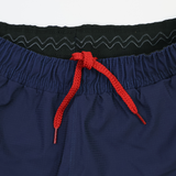Close-up of the waistband on the USA Rugby Pro Home Short 22/23 by Castore, featuring a red drawstring and a black elastic inner band with a wavy pattern.