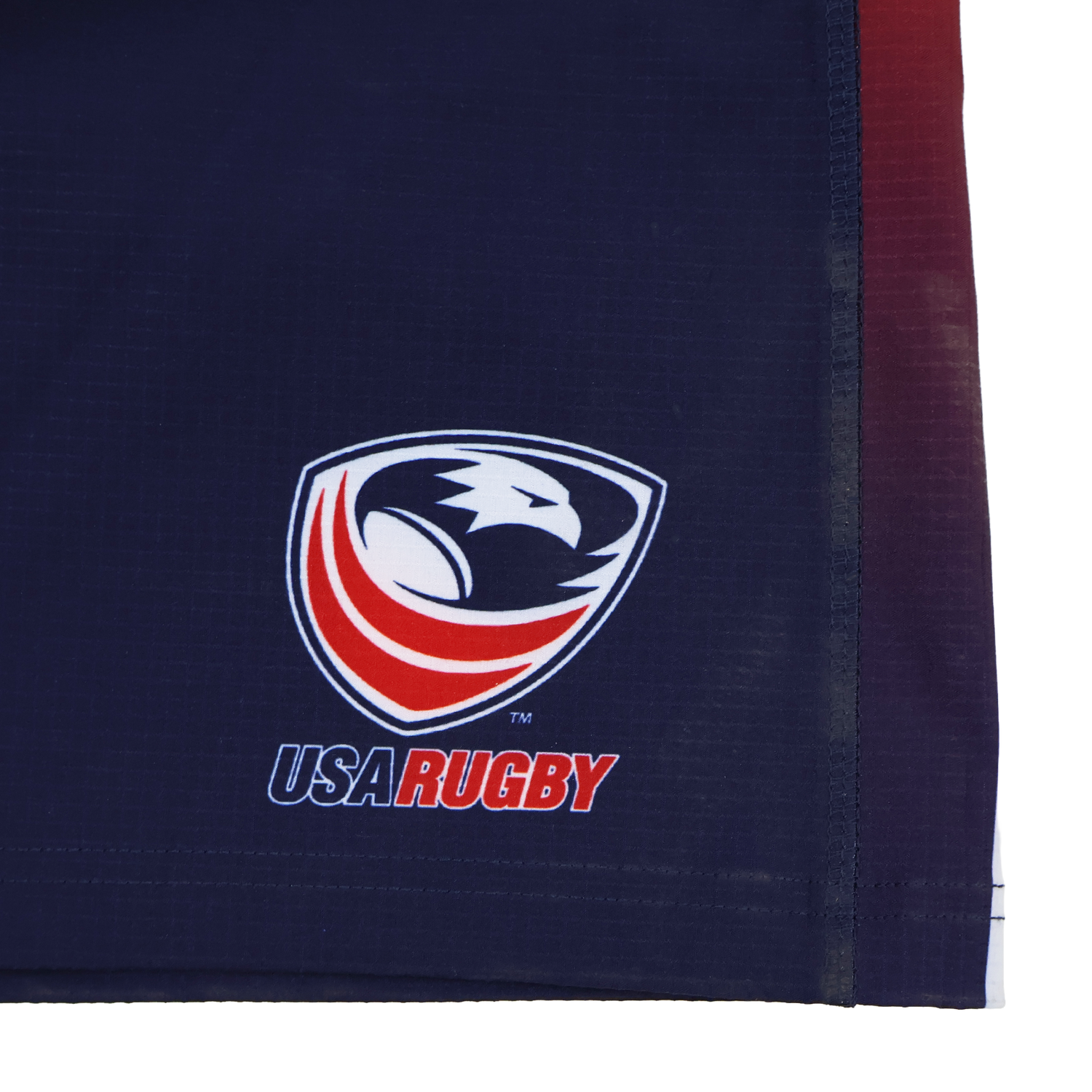 Close-up of a navy blue fabric with the USA Rugby logo and "USA RUGBY" text, featured on the official USA Rugby Pro Home Short 22/23 by Castore.