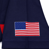 A close-up of the USA Rugby 22/23 Pro Away Jersey by Castore in navy blue, featuring a printed United States flag near the hem.