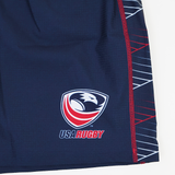 Close-up of the USA Rugby 22/23 7's RWC Away Pro Short by Castore in navy blue, featuring the USA Rugby logo and a geometric pattern with red, white, and blue lines down the side.