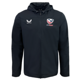 The USA Rugby Rain Jacket by Castore is black with a hood, features a zipper, the "Castore" logo on the left chest, and the "USA Eagles" logo on the right. It's designed with water-resistant technology and a lightweight mesh lining for comfort and protection.