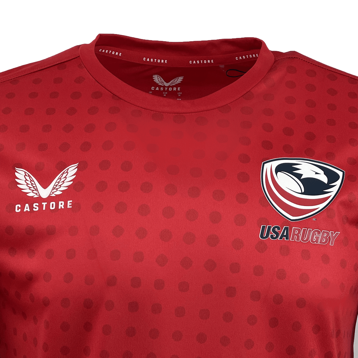 The USA Rugby Dot Printed Training Tee by Castore features a vibrant red hue and dotted texture, with the USA Rugby and Castore logos proudly displayed on the chest.