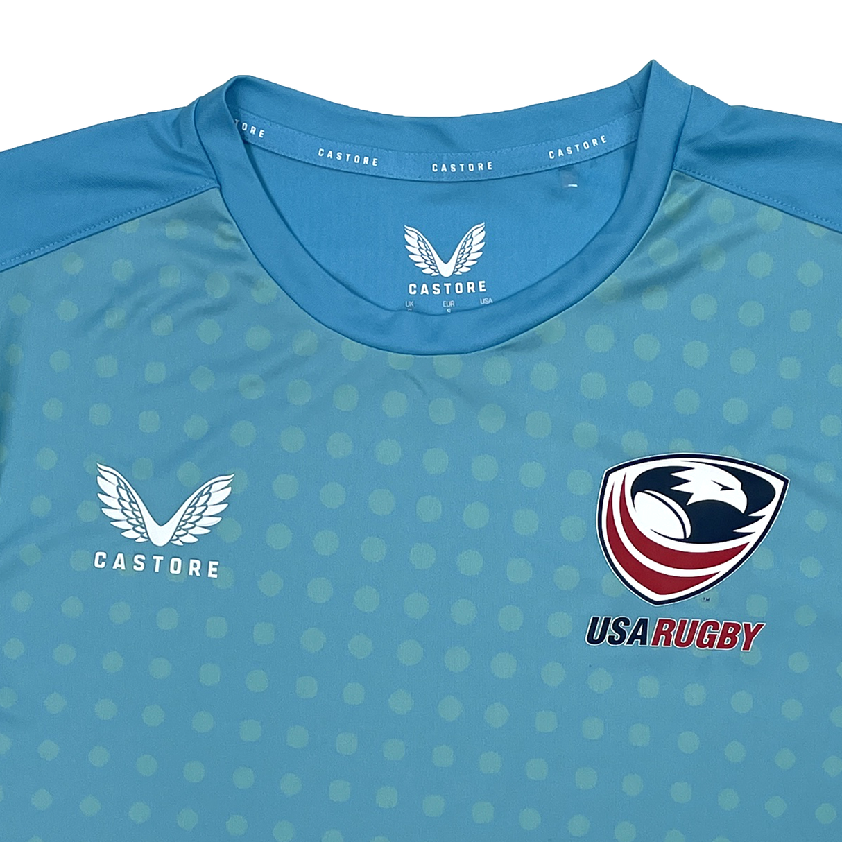 The USA Rugby Dot Printed Training Tee by Castore is a blue rugby jersey with a dotted pattern, featuring the Castore and USA Rugby logos, ideal for stylish training.