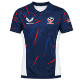 The USA Rugby 23/24 Pro Home Jersey by Castore is a blue men's rugby shirt with red and white accents, featuring the Castore logo, USA Rugby logo, and an American flag patch on the right sleeve—ideal for fans.