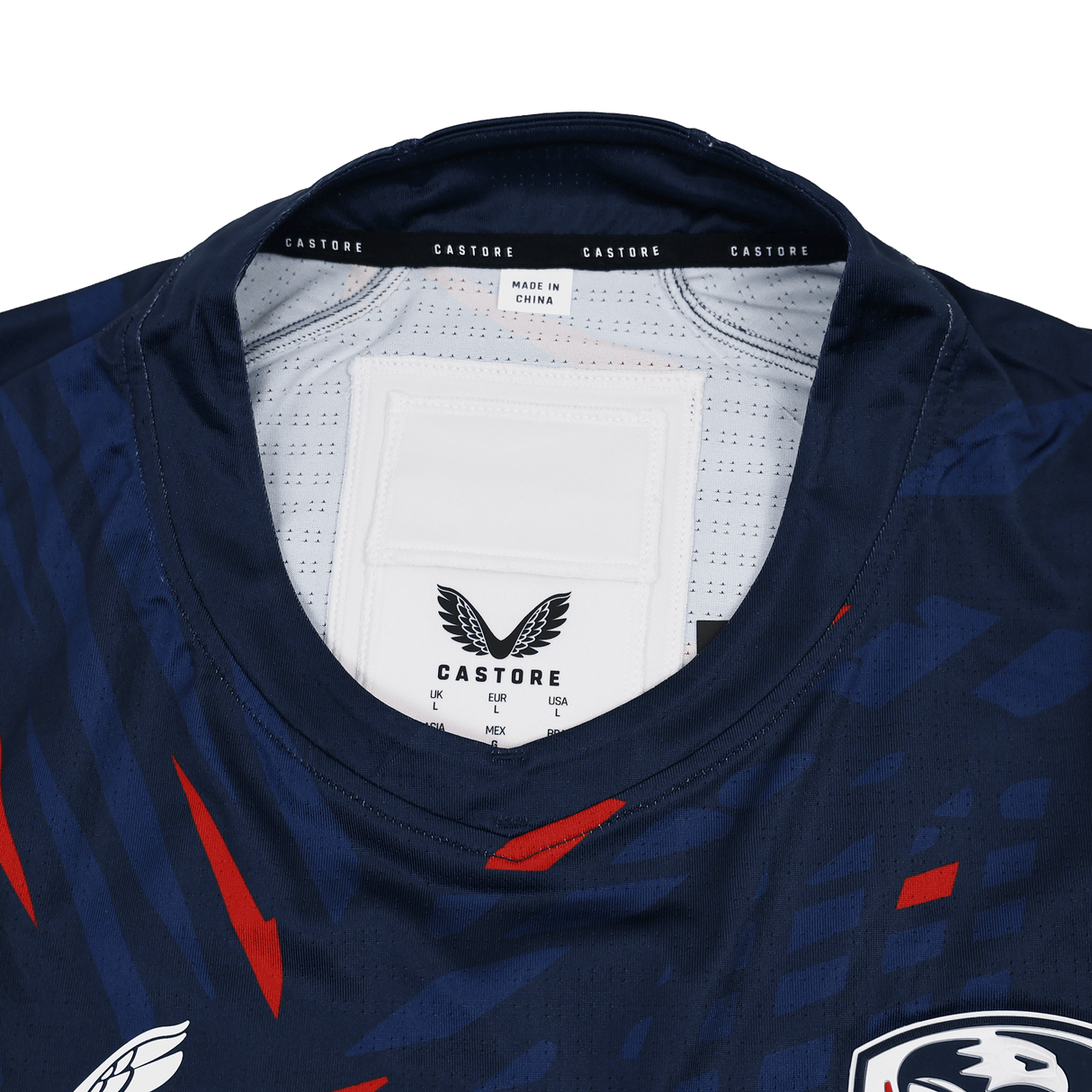 Close-up of the collar and inner label of the USA Rugby 23/24 Pro Home Jersey by Castore, featuring sizing details and a "Made in China" tag.