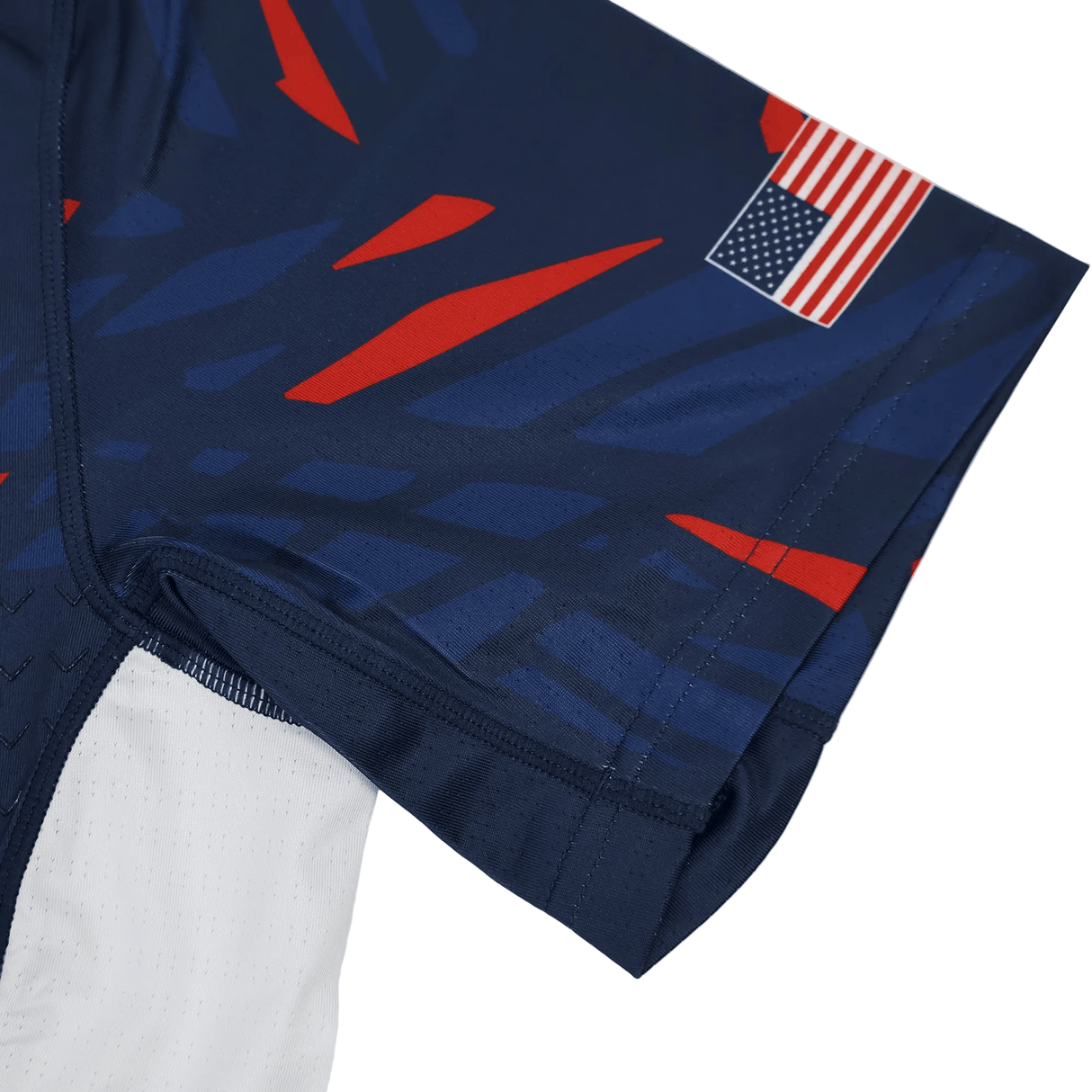 Close-up of the Castore USA Rugby 23/24 Pro Home Jersey in navy blue, featuring red and blue geometric patterns and a small United States flag patch on the sleeve.