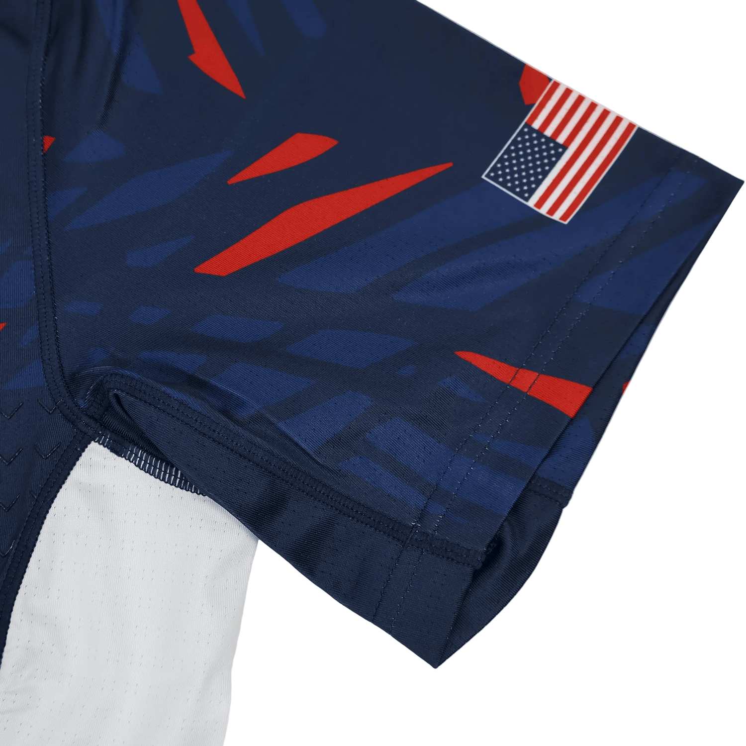 Close-up of the Castore USA Rugby 23/24 Pro Home Jersey in navy blue, featuring red and blue geometric patterns and a small United States flag patch on the sleeve.