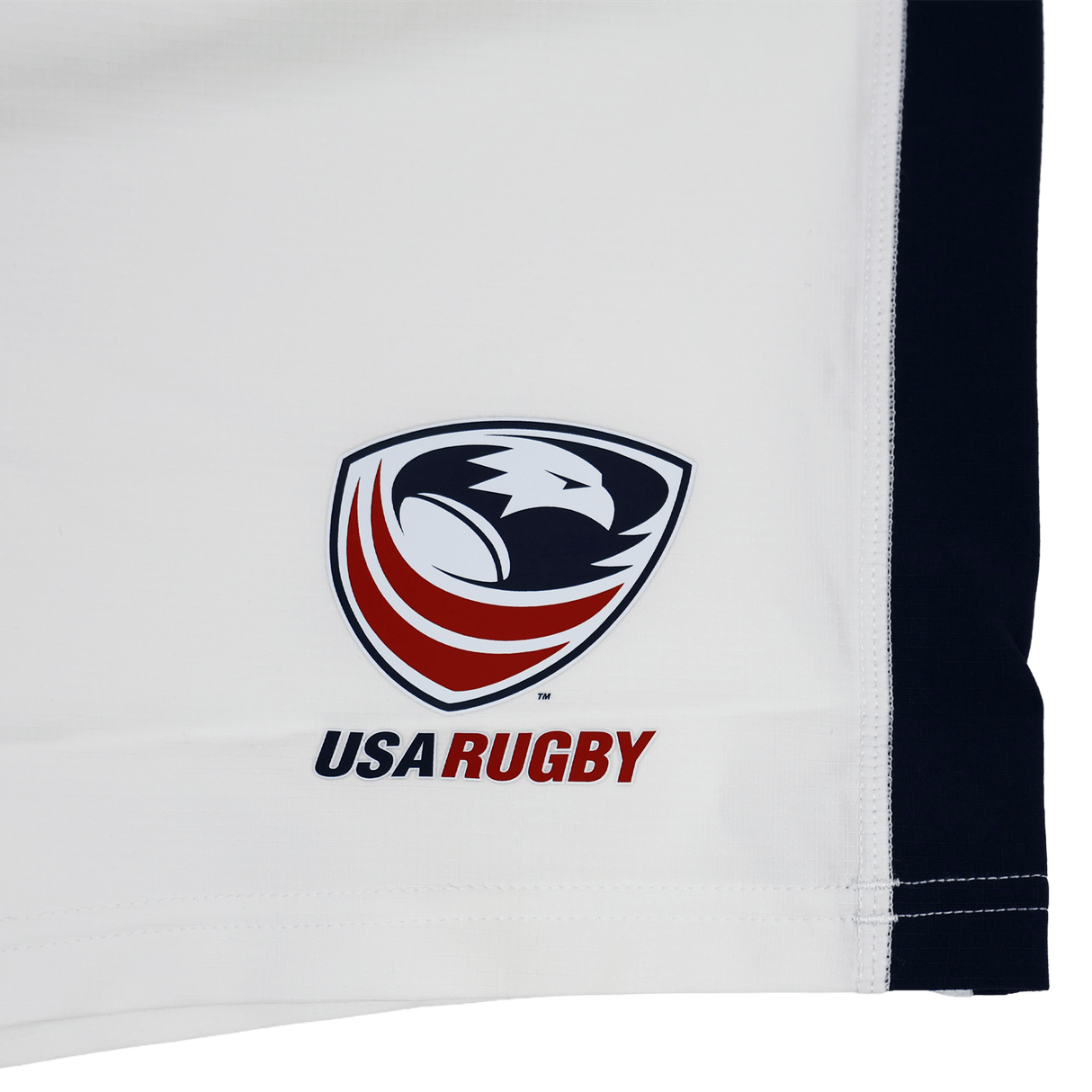 The USA Rugby 23/24 Pro Away Short by Castore is white with a stylized red, white, and blue eagle head USA Rugby logo, "USA RUGBY" text, Castore branding, and a black stripe on the right edge.