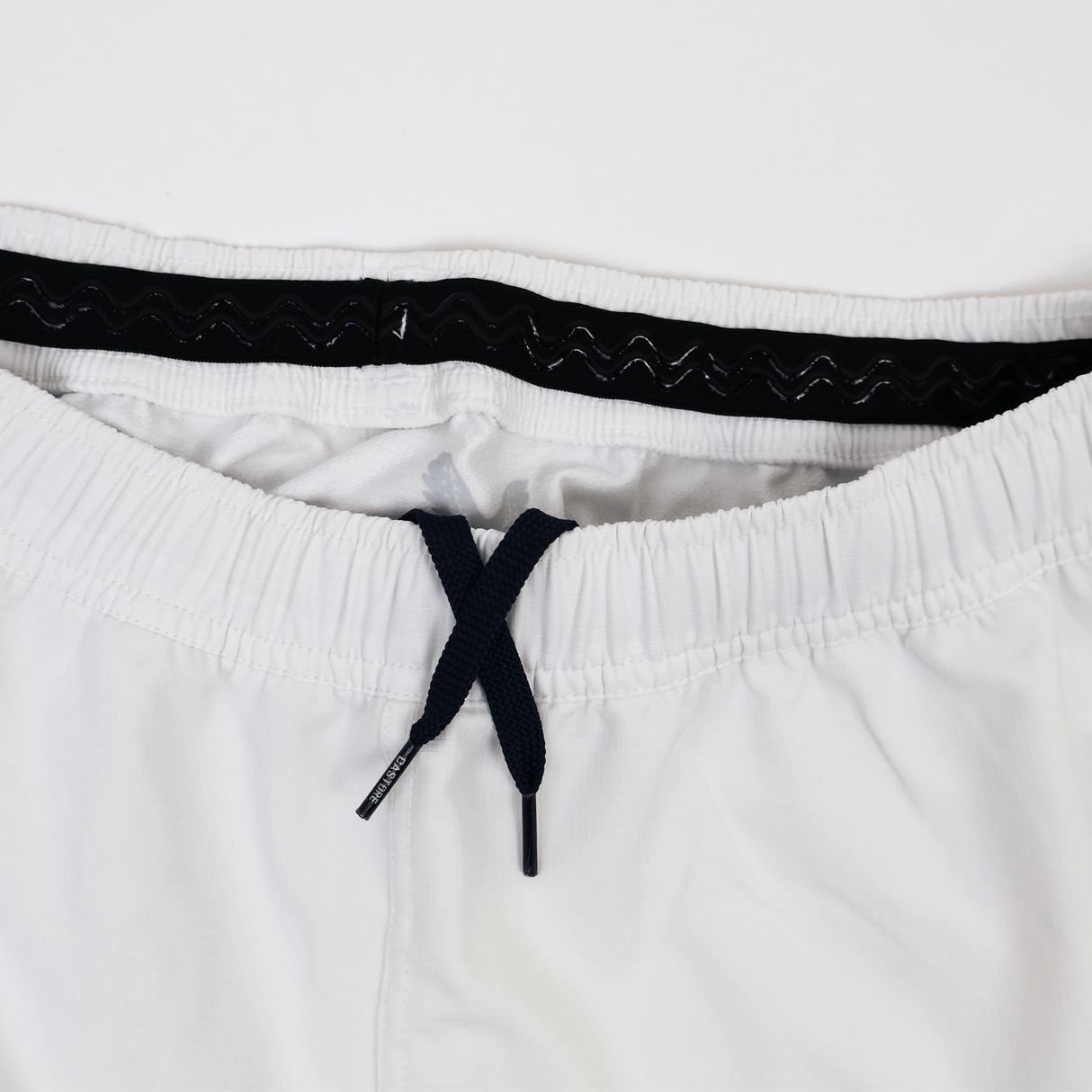 Close-up of the waistband on the Castore USA Rugby 23/24 Pro Away Short in white, featuring a black drawstring and inner elastic band, designed for USA Rugby athletes.