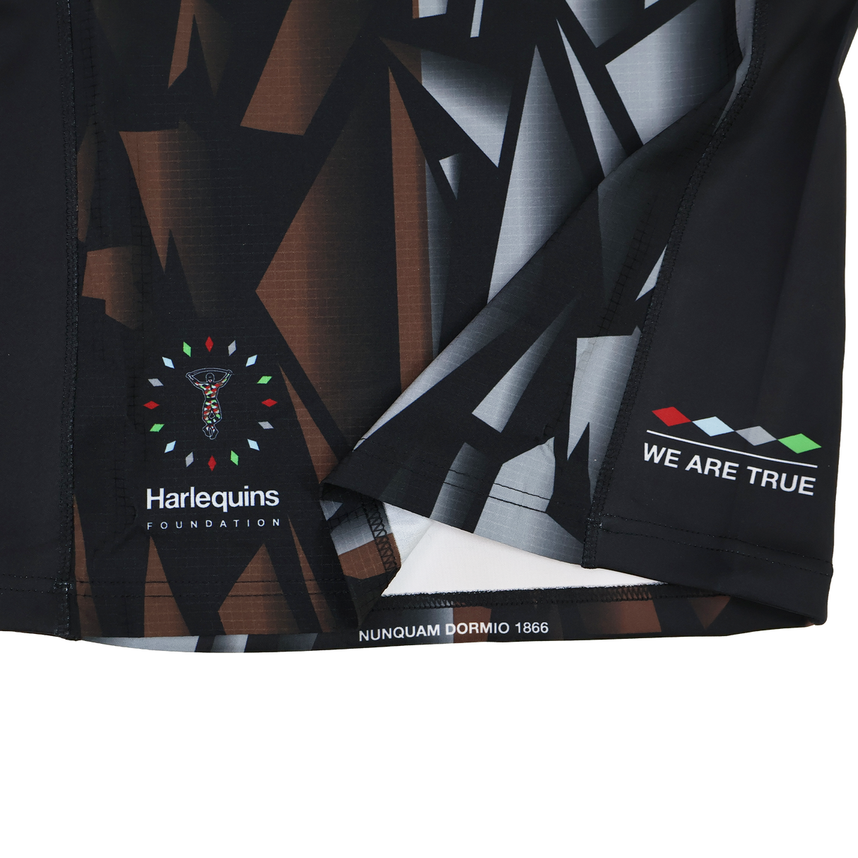 Close-up of the Harlequins 23/24 Pro 3rd Jersey by Castore, showing geometric patterns, Harlequins Foundation logo, and the phrases "WE ARE TRUE" and "NUNQUAM DORMIO 1866.