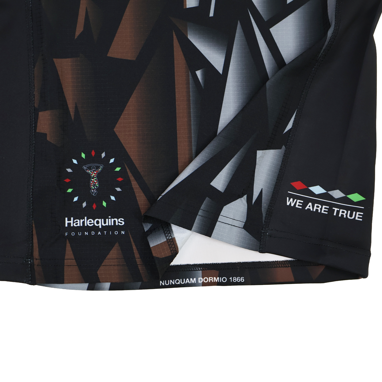 Close-up of the Harlequins 23/24 Pro 3rd Jersey by Castore, showing geometric patterns, Harlequins Foundation logo, and the phrases "WE ARE TRUE" and "NUNQUAM DORMIO 1866.