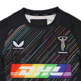 Close-up of the Harlequins 23/24 Pro Pride Jersey by Castore, a rugby jersey with vibrant rainbow stripes inspired by the Pride flag, plus DHL branding and the Harlequins emblem on the chest.