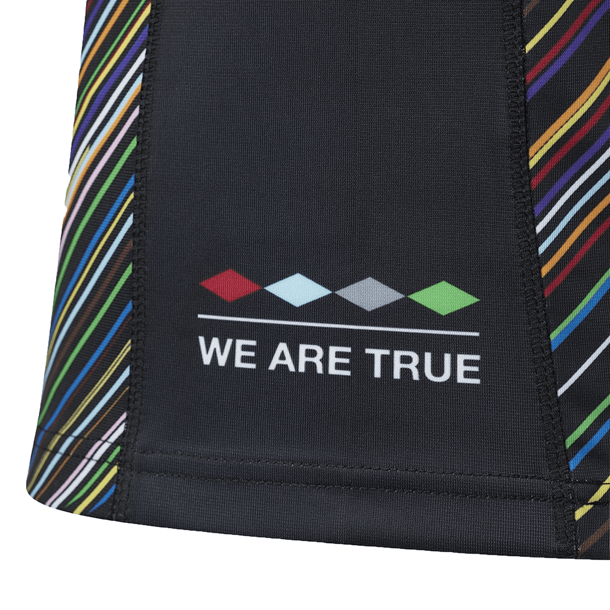 Close-up of the Harlequins Replica Pride Jersey 23/24 by Castore, featuring black fabric with multicolored diagonal stripes and "WE ARE TRUE" beneath a row of colored diamond shapes.