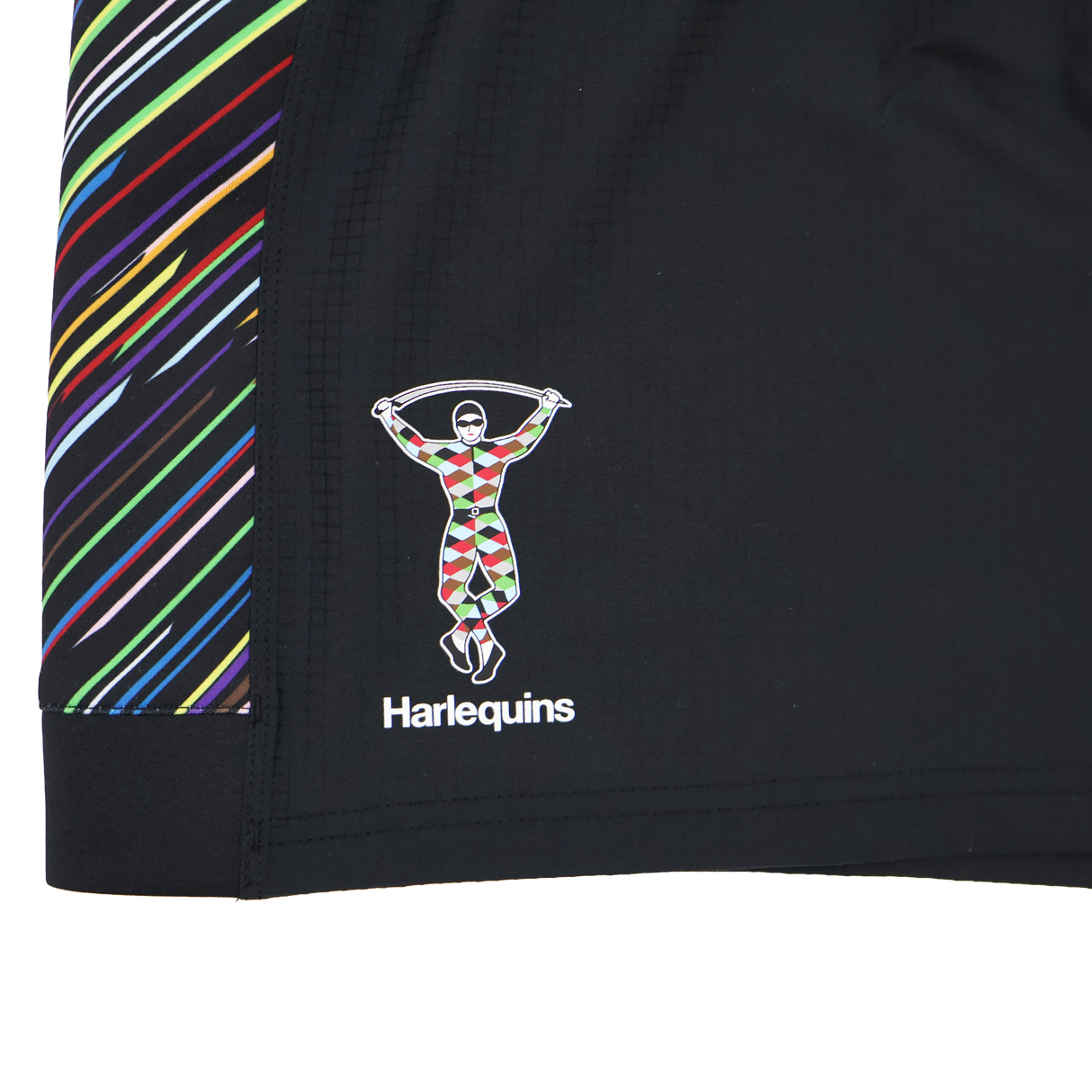 Close-up of black fabric on the Harlequins 23/24 Pro Pride Short by Castore, with multicolored diagonal stripes and the Harlequins logo—showcasing premium detail for athletic fit rugby shorts from Castore.