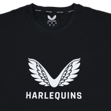 The Harlequins 23/24 Cotton Logo Tee by Castore is a black cotton tee with a white winged Harlequins logo above "HARLEQUINS" and Castore branding on the collar.