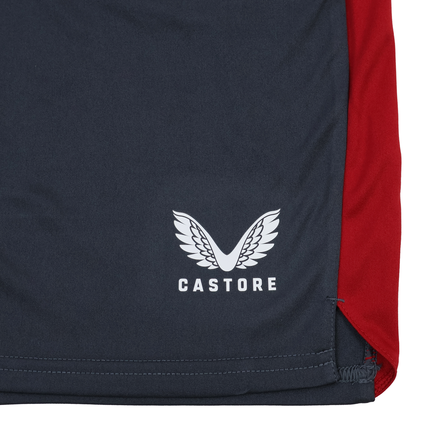 The Harlequins 23/24 Gym Short by Castore features navy blue fabric, a white stylized wings logo, a vertical red panel, and visible hem stitching—perfect for high-intensity workouts.