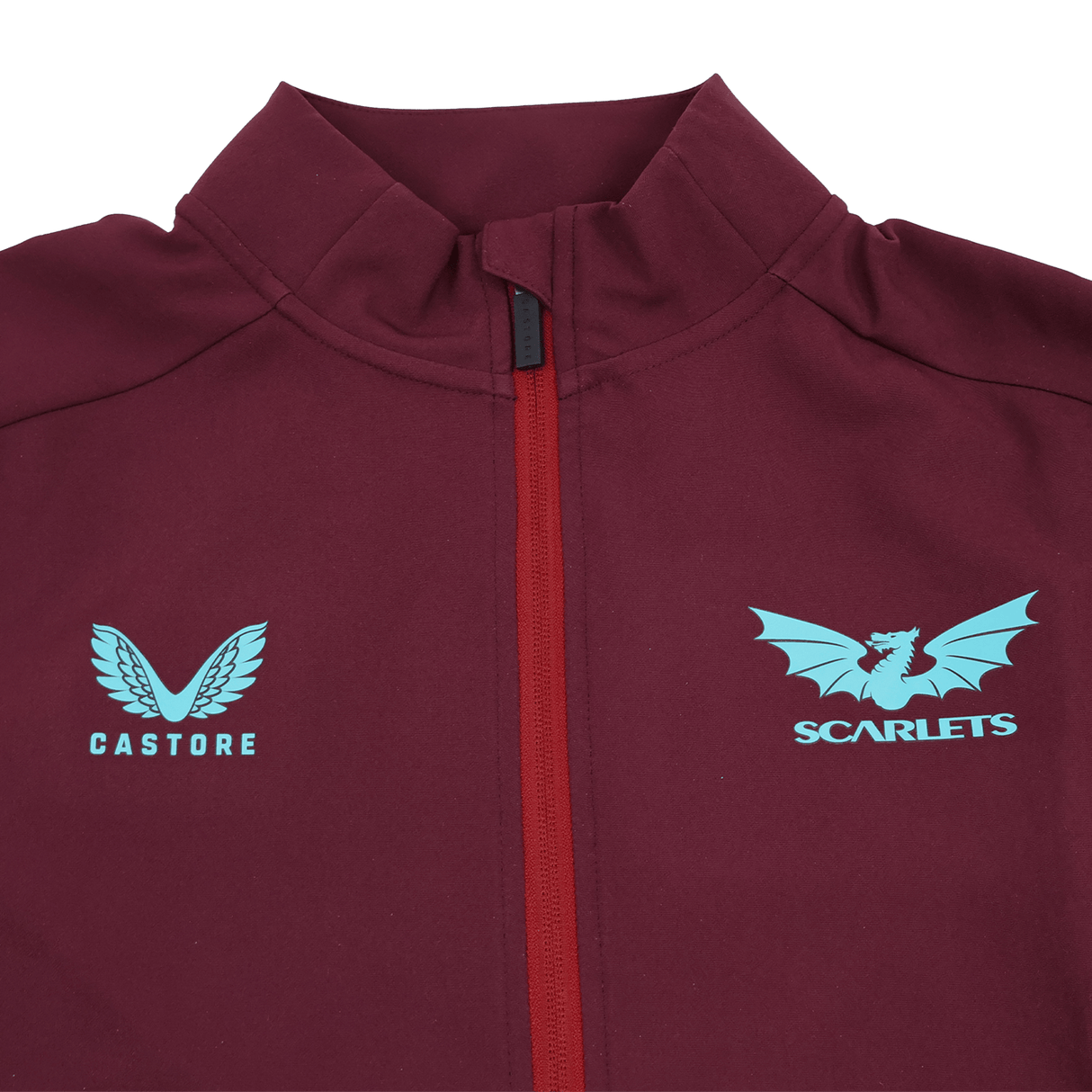 Close-up of the Scarlets 23/24 Travel Jacket Men's by Castore in maroon with a red zipper, blue Castore logo on the left side, and Scarlets dragon logo on the right.