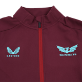 Close-up of the Scarlets 23/24 Travel Jacket Men's by Castore in maroon with a red zipper, blue Castore logo on the left side, and Scarlets dragon logo on the right.