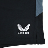 Close-up of Saracens Pro Home Shorts 23/24 by Castore, featuring black fabric, stylized wings and text logo, gray panel, and small side slit—crafted for elite performance.
