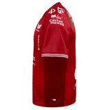Side view of the Scarlets Replica Home Jersey 23/24 by Castore, an athletic fit sports jersey in red with white and black trim on the sleeves, featuring multiple logos and text from various sponsors to honor Welsh rugby union.