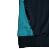 Close-up of the Bath 23/24 Full Zip Hoodie by Castore, featuring a teal and black color block design, zippered pocket, and ribbed black hem—stylish official fan apparel from Castore.