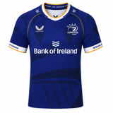 The Leinster 23/24 Replica Home Jersey by Castore features blue with white and gold accents, "Bank of Ireland" sponsor, and Castore logos. Official replica jersey for dedicated Leinster Rugby fans.