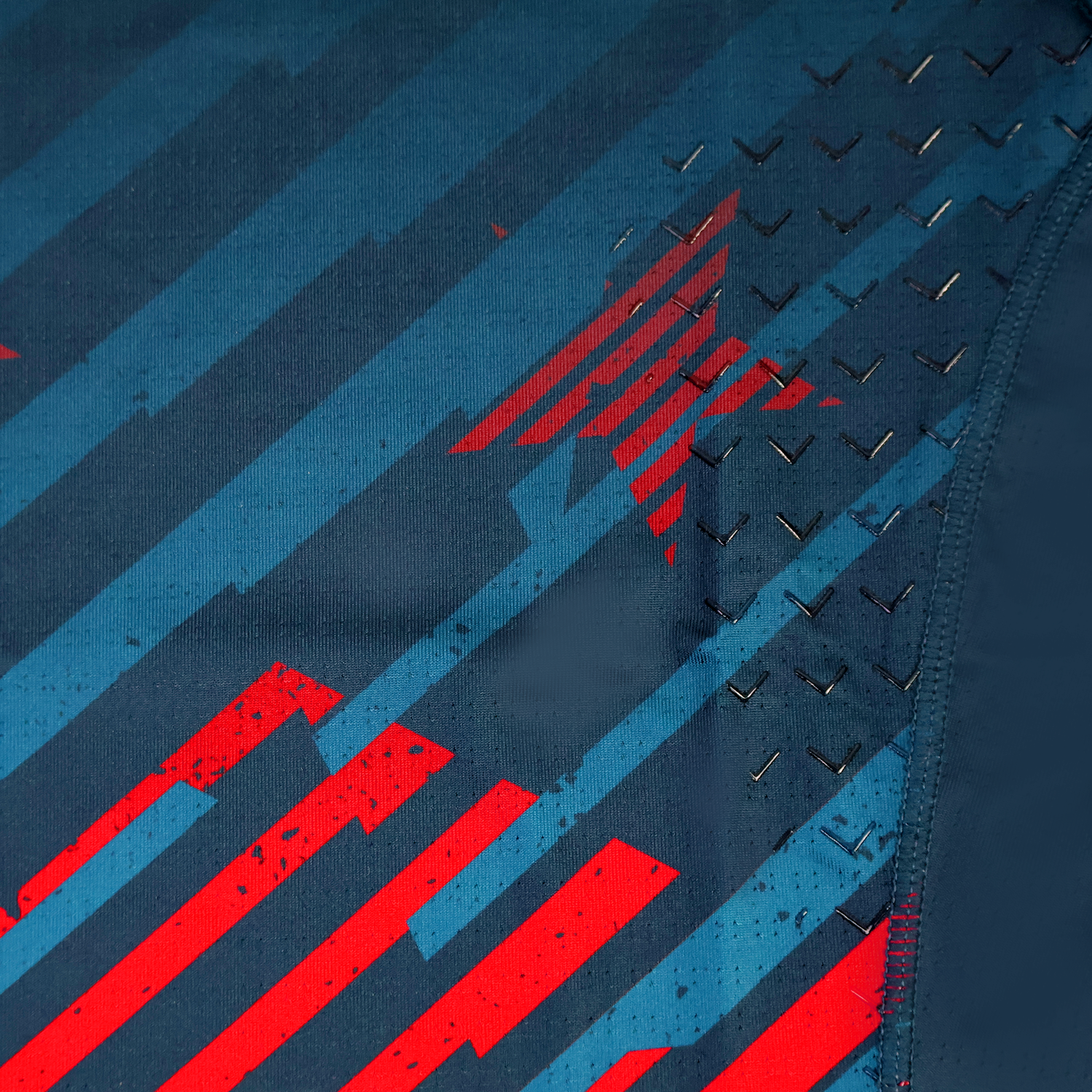 Close-up of the USA Rugby 24/25 Pro Home Jersey by Castore, showing its diagonal blue and red stripes, red star pattern, and textured chevron grip details.