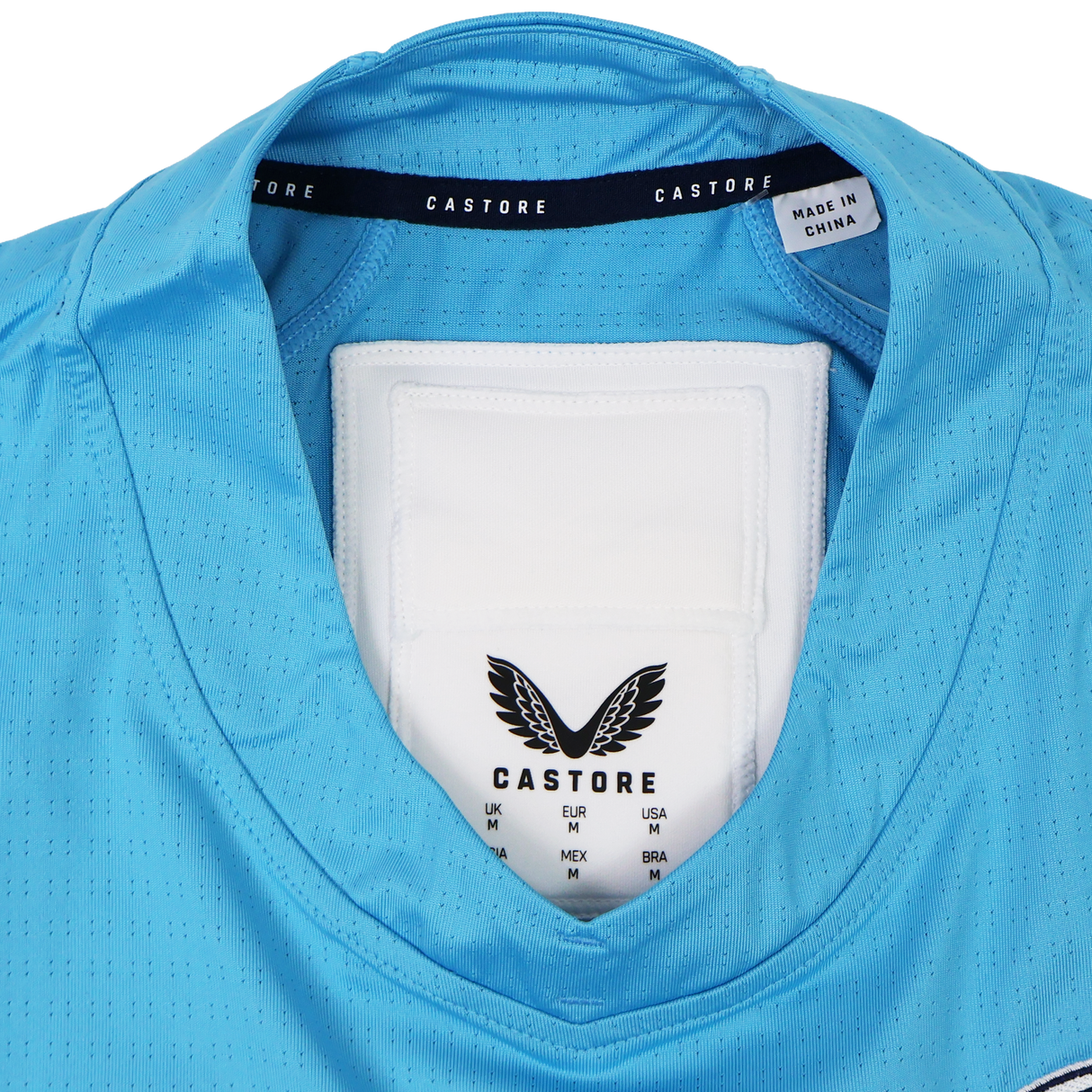Close-up of the USA Rugby 24/25 Pro Training Jersey by Castore in light blue, highlighting the collar’s reinforced seams, brand label & GPS pocket—ideal for USA Rugby supporters.